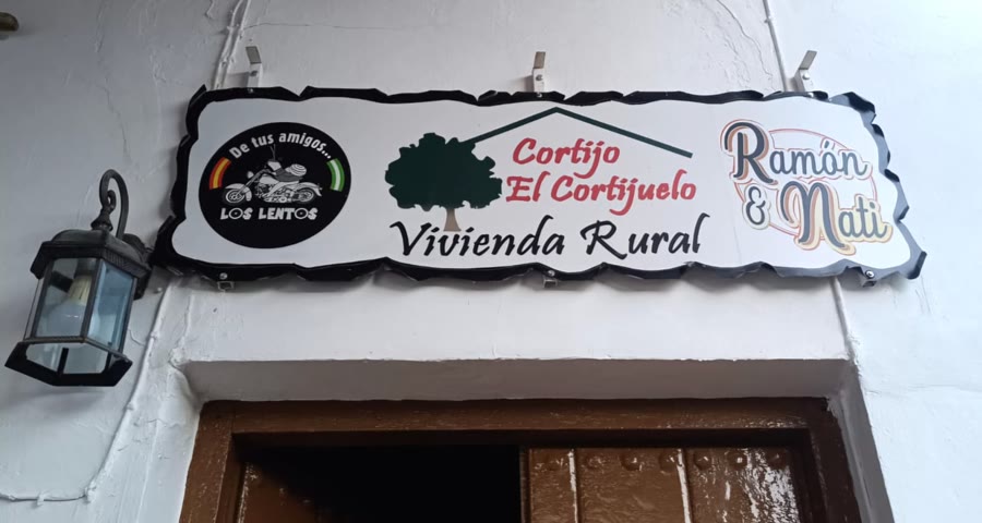Cartel de bienvenida al Cortijo El Cortijuelo, con letrero de Ramón & Nati