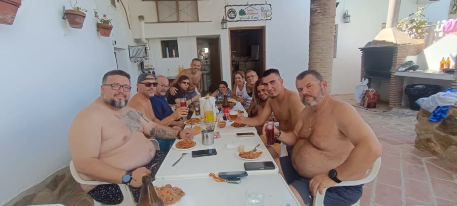 Grupo completo comiendo en una mesa larga